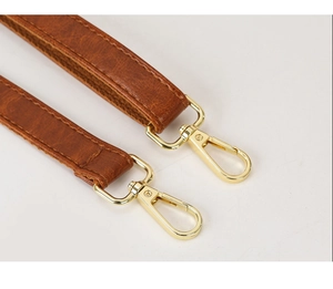 Detail of vintage brown leather strap with polished golden metal lobster clasps