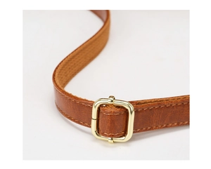 Detail of adjustable brown leather shoulder strap with a polished gold metal buckle