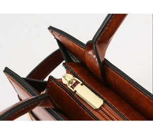 Macro detail of brown retro leather handbag showing gold zipper and neat black edge oiling
