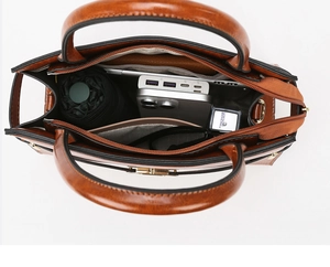 Interior storage view of brown leather handbag with slots for phone and cosmetics