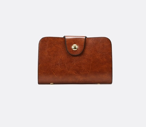 Detailed macro view of vintage brown leather wallet with golden round metal buckle