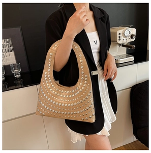 Schicke khakifarbene Hobo-Tasche mit silbernen Metallnieten, getragen von einem Model