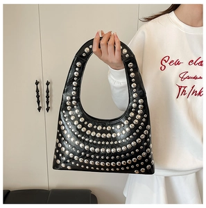 Detail der schwarzen Hobo-Tasche mit Silbernieten und polierter Öl-Wachs-Lederstruktur