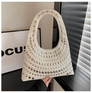Details einer cremefarbenen Lackleder-Schultertasche mit silbernen Nietendetails