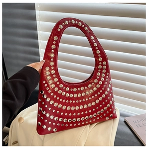 Detail der roten glänzenden Ledertasche mit dekorativen silbernen Metallnieten und Nieten