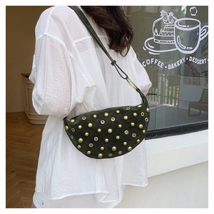 Detail of dark moss green suede crescent bag with gold stud rivets and metal eyelets