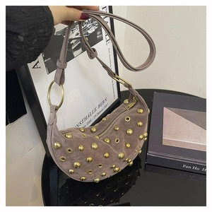Détail du sac hobo en daim gris-mauve avec rivets vintage et anneaux dorés design