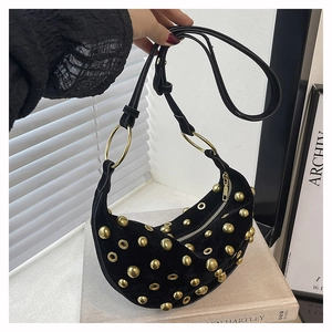 Gros plan détaillé du sac croissant en velours avec rivets dorés et œillets décoratifs