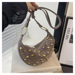 Détail du sac croissant en daim à rivets avec œillets métalliques et style vintage