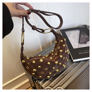 Vue détaillée d'un sac hobo en daim marron foncé avec clous dorés et œillets décoratifs