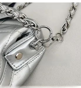 Dettaglio macro della borsa in pelle trapuntata argento con catena e gancio metallico