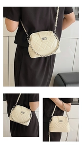 Dettaglio borsa a tracolla trapuntata beige con catena argento e chiusura a girello