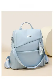 Detail eines hellblauen Rucksacks aus Kunstleder mit silbernen Akzenten und Quasten
