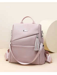 Detail eines rosa Rucksacks mit Lychee-Ledertextur und schickem Quastenanhänger-Dekor