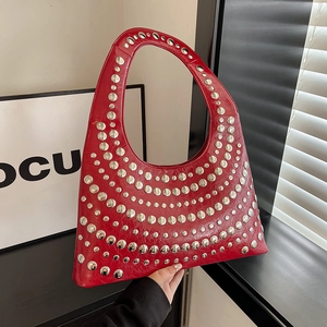 Rote hobo tasche mit silbernen nieten und glänzendem lederfinish bei natürlichem licht