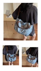 Detail of vintage washed blue tote bag with brown leather handles and silver metal hardware