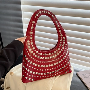 Moderne rote Hobo-Tasche mit Silbernieten und poliertem Lackleder in einer Handansicht