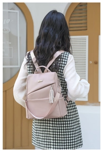 Detail des rosa Anti-Diebstahl-Rucksacks mit Kieselmaserung und Quastenanhänger