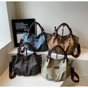 Detail view of large canvas tote bags in four retro colors with leather handles and straps