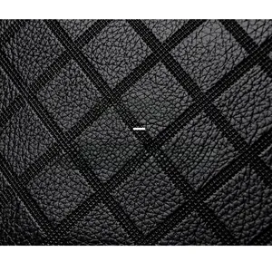 Close-up of black leather texture showing soft lychee grain and quilted diamond stitching