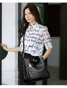 Detail of black multi-zip crossbody bag featuring quilted rhombus pattern and chain pendant