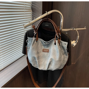 Dettaglio della borsa tote vintage in tela con manici in pelle e occhielli metallici