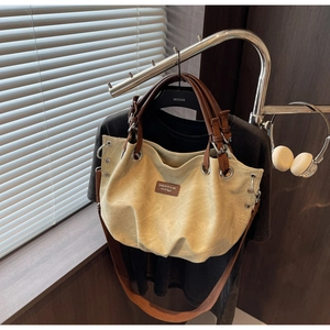 Dettaglio della borsa tote in tela vintage con manici in pelle marrone e anelli in metallo