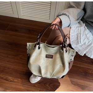 Dettaglio della borsa tote vintage in tela con finiture in ecopelle marrone e tracolla