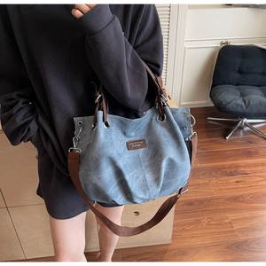 Dettaglio della borsa tote in tela retrò con texture grigio-blu e tracolla larga