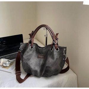 Detailed view of large grey washed tote bag with brown handles and adjustable strap