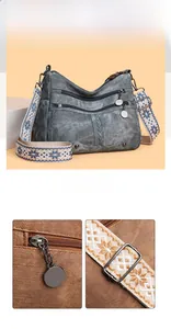 Detail of grey vintage crossbody bag with wide woven strap and multi-zipper compartments