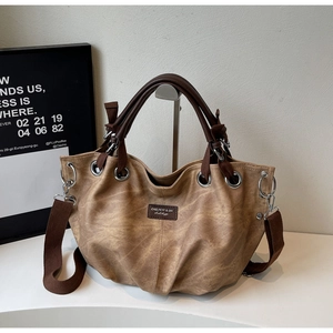 Dettaglio borsa tote vintage in pelle PU marrone con occhielli e tracolla in tessuto