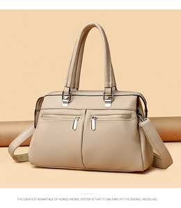 Close-up of beige lychee texture faux leather with silver zippers and stitching detail