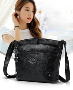 Détail du sac bandoulière en cuir noir avec triple fermeture éclair et pendentif kangourou