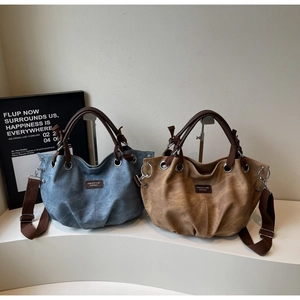 Dettaglio di borse tote in tela vintage con toppe logo in pelle e robuste tracolle
