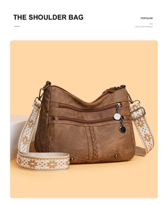 Detail of vintage brown soft leather shoulder bag with ethnic style embroidery strap
