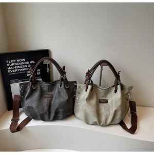 Dettaglio di borse tote vintage in tela antracite e verde salvia con manici in ecopelle