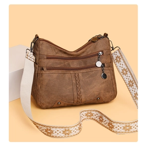 Detail of vintage brown soft leather crossbody bag with ethnic patterned strap