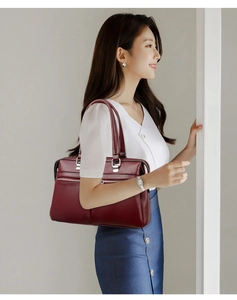 Detailed view of burgundy soft leather tote bag with lychee texture and silver hardware