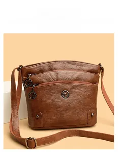 Détails d'un sac bandoulière en similicuir marron avec plusieurs poches zippées