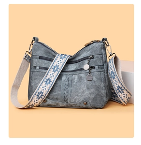 Close-up of vintage grey multi-pocket crossbody bag with blue snowflake pattern strap