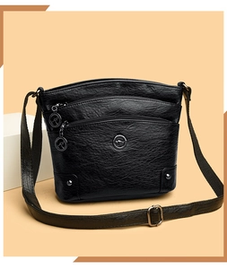 Détail du sac à bandoulière en cuir grainé noir avec trois zips et logo kangourou