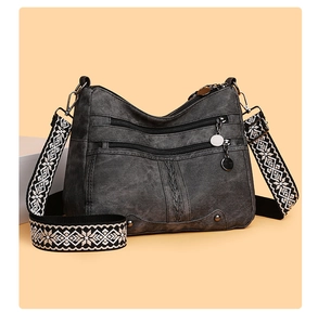 Detailed view of a dark grey retro crossbody bag with geometric woven strap and zippers
