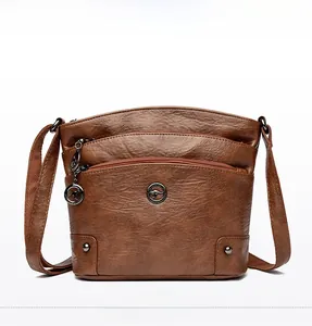 Vue détaillée du sac bandoulière en cuir souple marron avec triple fermetures