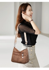 Close-up of retro brown soft leather crossbody bag with ethnic style embroidery strap