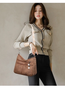 Detail of soft brown leather crossbody bag with three zippers and jacquard woven strap