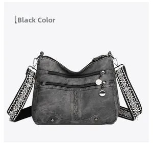 Detail of black soft leather crossbody bag featuring ethnic style woven strap and multi-pockets
