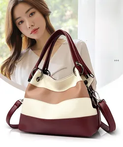 Detail of tricolor leather handbag with metal ring handle and pebble grain texture
