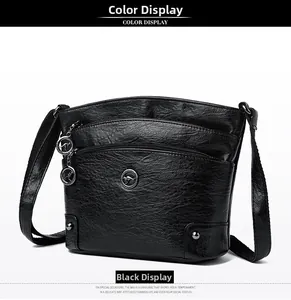 Détail du sac bandoulière en cuir noir avec zips et logo kangourou métallique