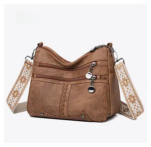 Close-up of retro brown soft leather shoulder bag with multi-zippers and embroidery strap